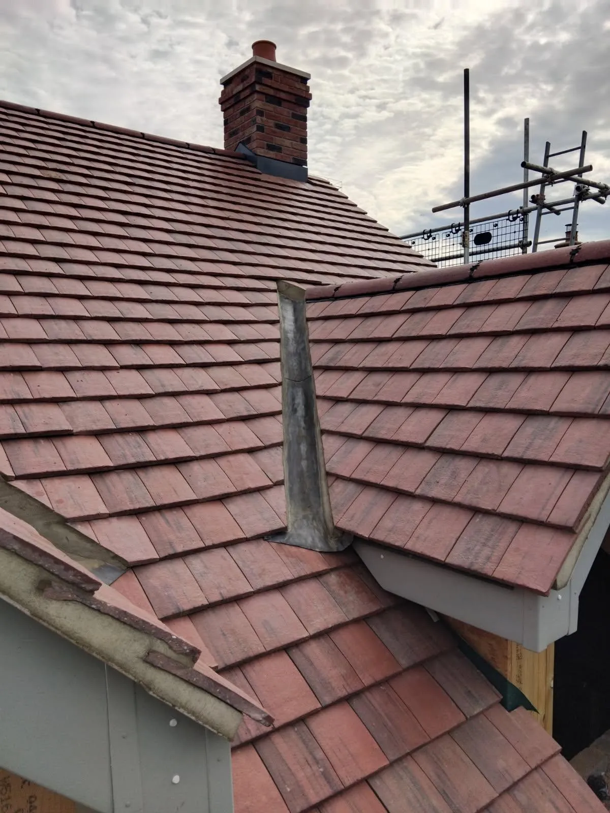 New clay plain-tile roof with lead chimney flashing and valley