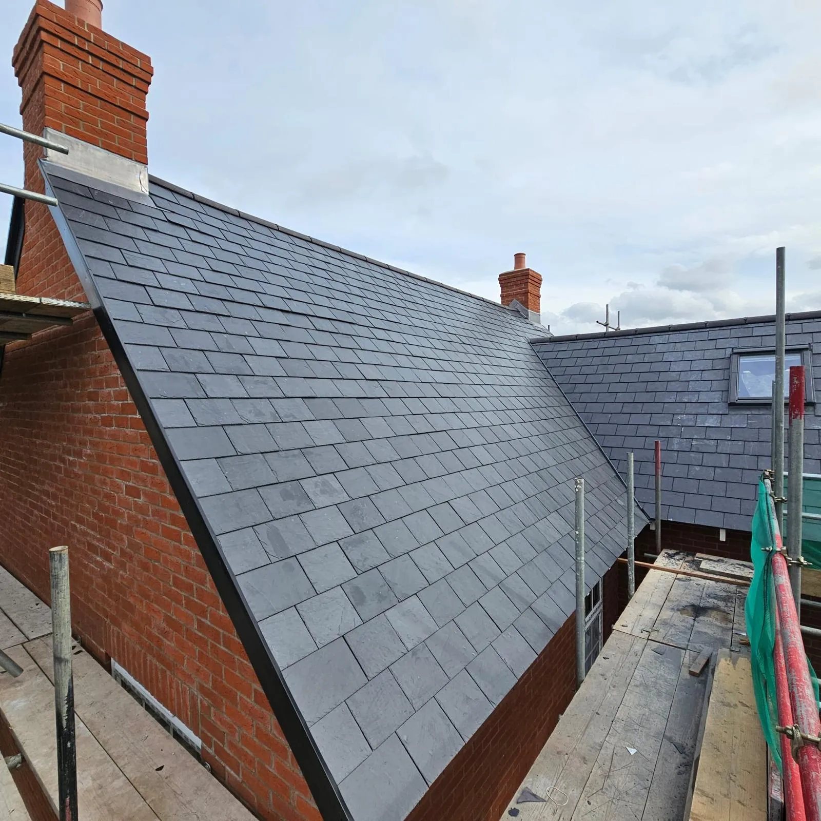 New natural slate roof with fresh lead flashing to the chimney
