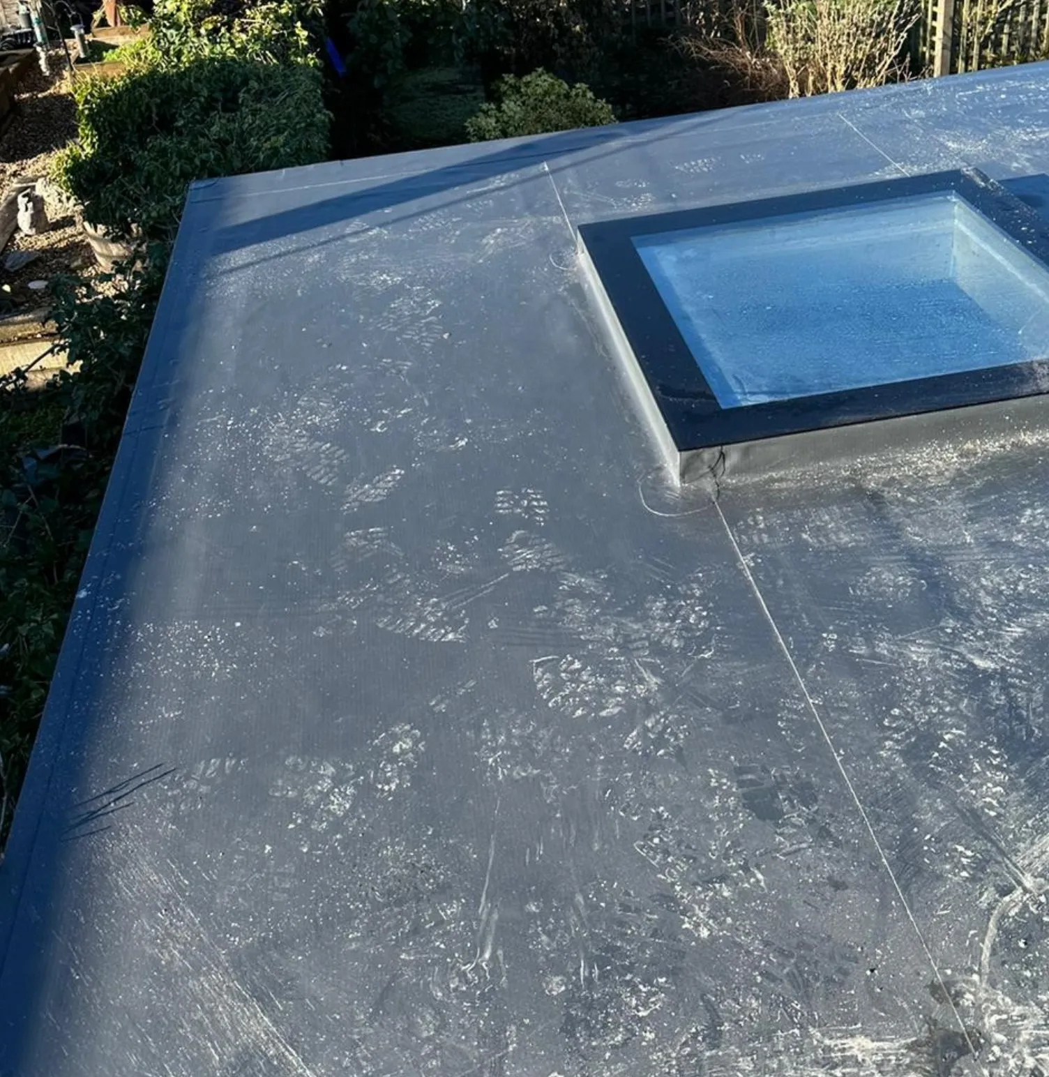 Dark grey rubber membrane flat roof with rooflight