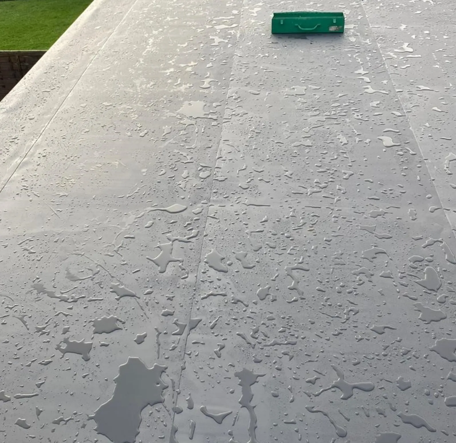 Rainwater beading on a flat roof membrane