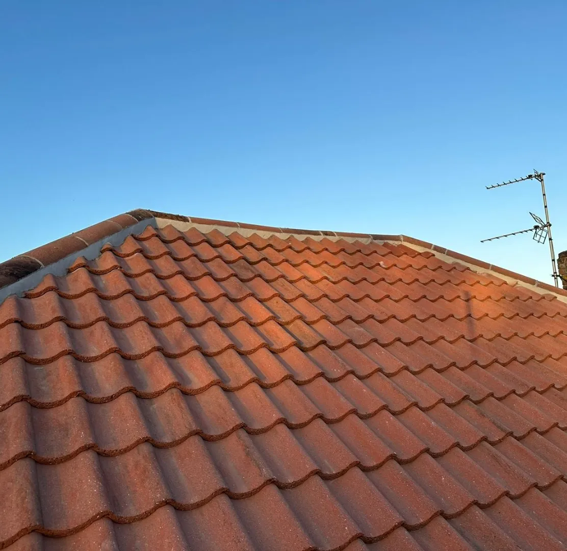 New tiled pitched roof against a blue sky