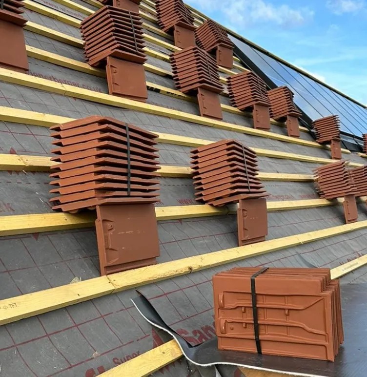 Pitched roof mid-install with battens and stacked clay tiles